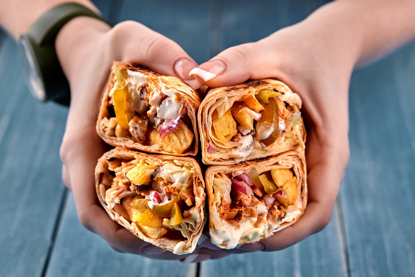 Shawarma Chicken Roll in a Pita with Fresh Vegetables, Cream Sauce and French Fries on Wooden Background. Selective Focus